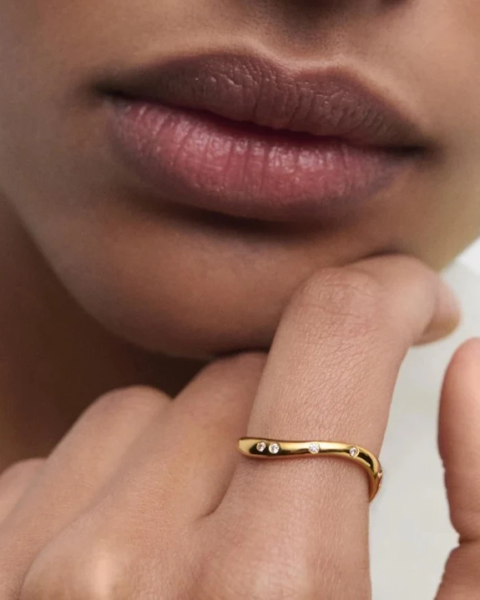 Anillo elegante adornado con circonitas y líneas fluidas